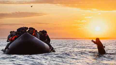 People smugglers force migrants onto flimsy boats for the dangerous English Channel crossing | Photo: Sameer Al-Doumy/AFP