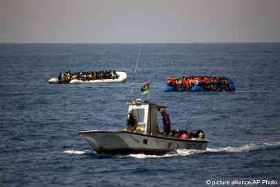 From file: A Libyan Coast Guard ship sails past two rubber boats with migrants and refugees in the Mediterranean Sea, about 18 miles north of Sabratha, Libya, June 15, 2017 | Photo: Emilio Morenatti / AP Photo