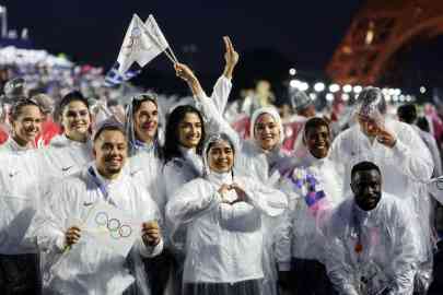 © AFP/POOL - CAMERON SPENCER | Members of the Refugee Olympic Team celebrate at the close of the Paris Olympics opening ceremony by the Eiffel Tower on 26 July 2024.