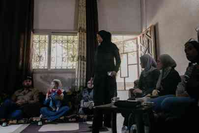 Rana Kassem Al-Khobi, is 34 years old, pictured here in the family's front room in Deraa, where several families came together to talk on September 24, 2025 | Photo: Valentina Camu / Divergence