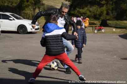 Guido Fluri plays football with some of the Ukrainian children he helped bring to safety in Switzerland | Photo: Anthony Anex / Keystone / Picture alliance