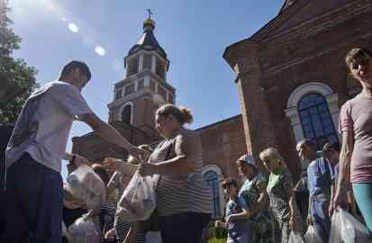 Volunteers distributing humanitarian aid near an Orthodox church in Kharkiv, Ukraine | Photo: ARCHIVE/EPA/SERGEY KOZLOV