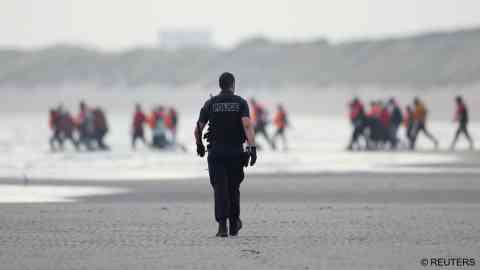 File photo: French police try to stop a group of migrants as they walk on the beach in an attempt to get on an inflatable dinghy to cross the English Channel to reach Britain, from the beach of Petit-Fort-Philippe in Gravelines, near Calais, France, July 2, 2025 | Photo: Gonzalo Fuentes / Reuters