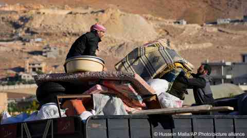 Syrian refugees arrange their belongings on a truck, as they prepare to go back home to Syria from the eastern Lebanese border town of Arsal on May 14, 2024 | Photo: Hussein Malla/AP Photo/ picture alliance