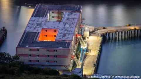 From file: A picture of the Bibby Stockholm barge moored in Portland Harbor, UK, just one of two large sites that the government has actually opened since spending millions on its plans | Photo :James Manning / PA Wire / picture alliance