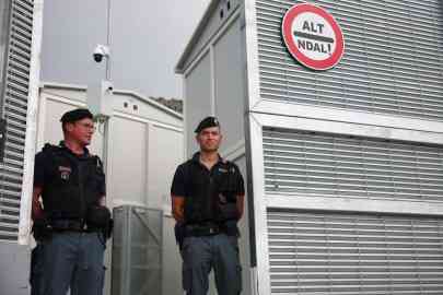 Italian police officers stand inside the reception camp at the port in Shengjin, Albania, on October 11, 2024 | Photo: Florion Goga / Reuters