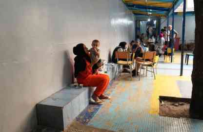 A woman holds her grandchild in her arms at a school in Beirut that has been turned into a collective shelter for people fleeing Israeli air raids | Photo: UNHCR / HOUSSAM HARIRI