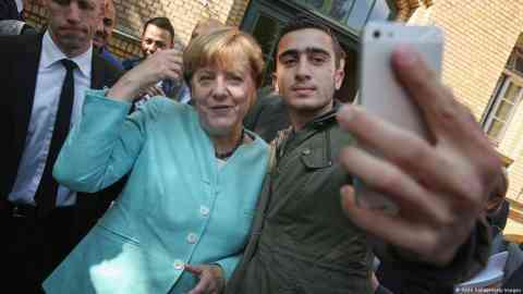 This selfie by Anas Modamani, a Syrian refugee, with Chancellor Angela Merkel went viral | Photo: Sean Gallup / Getty Images via DW