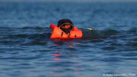 File photo used as illustration: This migrant is seen trying to swim to an inflatable dinghy in an attempt to cross the English Channel from Calais, France, on September 27, 2025 | Photo: REUTERS/Abdul Saboor