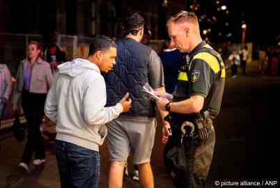 Passers-by talk to police and take information on a fatal attack on an asylum seeker in the Netherlands in July 2024 | Photo: Lina Selg / picture alliance / ANP