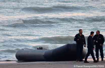 From file: French policemen stand beside a dinghy lying on the beach which failed to cross the Channel in November 2022 | Photo: Pascal Rossignol/Reuters