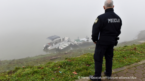 A Croatian police officer looks from the shore of the Sava river near the site where a boat carrying migrants from Bosnia overturned in eastern Croatia, near Slavonski Brod | Photo: Nenad Opacak / AP Photo