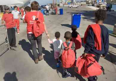 Migrant children assisted by Save the Children volunteers after disembarking on Lampedusa | Credit: Save the Children