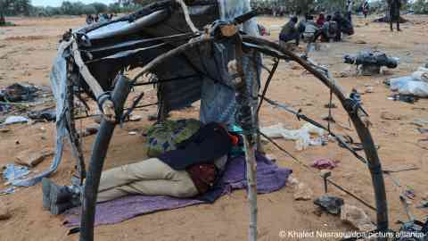 File photo: A migrant from sub-Sahara Africa rests inside the remains of a tent in a camp in Jebeniana in Tunisia | Photo: Khaled Nasraoui / dpa / picture alliance