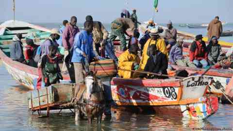 Senegal's iconic fishing boats increasingly transport a different kind of cargo these days | Photo: Robert Harding/picture-alliance