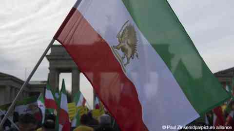 File photo used for illustration: Demonstrators waving a Persian flag in Berlin's Pariser Platz on January 6, 2018, protesting against the Iranian government system. The opposition National Council of Resistance of Iran (NCRI) had called for the event | Photo: Picture-alliance/Paul Zinken