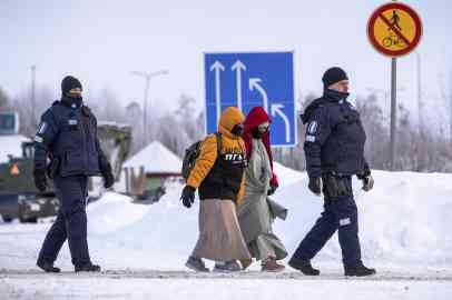 Asylum seekers accompanied by Finnish border police personnel as they arrive at the border station Vartius in northern Finland near Kuhmo | Photo: ARCHIVE/EPA/JANNE KURONEN