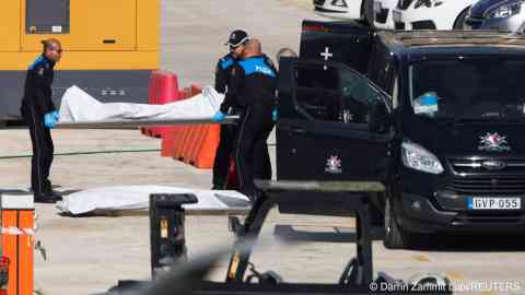 Police officers carry the body of a drowned migrant into a hearse, after a boat carrying some 34 migrants capsized off Malta, at the Armed Forces of Malta maritime squadron base at Haywharf in Valletta's Marsamxett Harbour, Malta February 23, 2024 |  Photo: REUTERS/Darrin Zammit Lupi