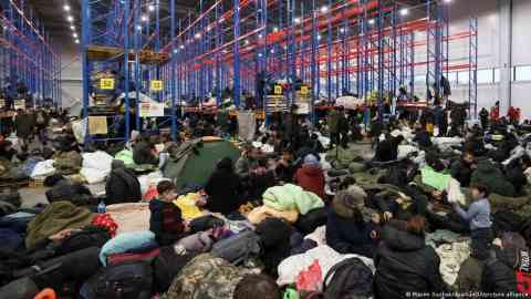 Migrants rest in a logistics center at the checkpoint "Kuznitsa" at the Belarus-Poland border near Grodno, Belarus, Friday, November 19, 2021 | Photo: Maxim Guchek/dpa/picture-alliance