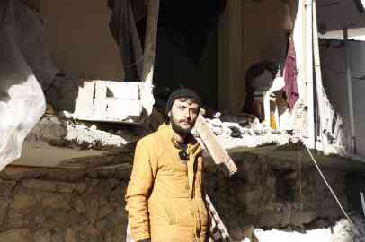Mustapha poses in front of the building where he lived with his parents, in downtown Antakya | Photo: Infomigrants