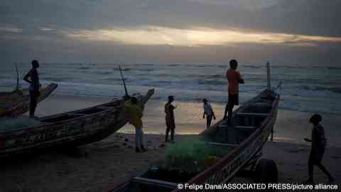 From file: Senegalese youth gather around pirogues on the beach at dusk in Fass Boye, Senegal  | Photo: Felipe Dana/Associated Press/picture alliance