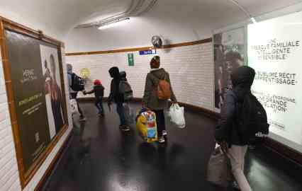Maryam and her five children walk in a Parisian metro hallway. Photo : Mehdi Chebil for InfoMigrants