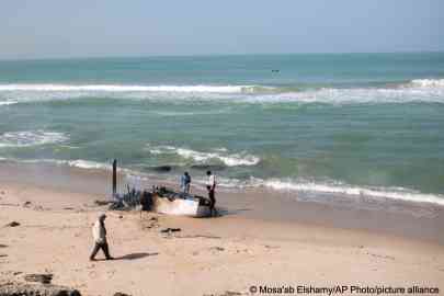 Des enfants jouent sur un bateau de pêche que des passeurs avaient l'intention d'utiliser pour transporter des migrants, mais qui
a été incendié par les autorités, près de La Sarga, juste à l'extérieur de Dakhla, dans le Sahara occidental sous administration marocaine, en 2020. Crédit : Picture alliance