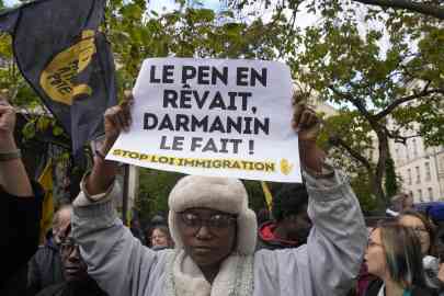 © Michel Euler, AP | A protester holds a paper reading: "Le Pen dreamed of it, Darmanin does it" during a demonstration in front of the Senate in Paris, Monday, November 6, 2023.