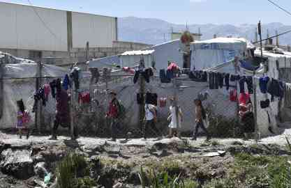 Syrian refugee children walking next to makeshift shelters in a Syrian refugee camp in the Marj area at Bekaa Valley, Lebanon. | PHOTO/ARCHIVE/EPA/WAEL HAMZEH