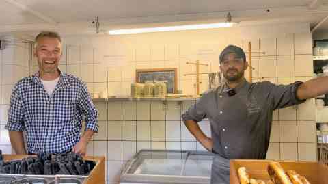 Hassan Hedayati and his boss Manfred Valentin at the food counter of the Mariabrunn beer garden | Photo: Natasha Mellersh / InfoMigrants