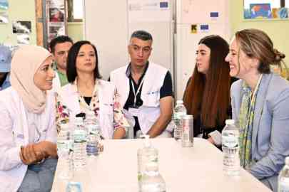 IOM Director General Amy Pope (on the right) with residents of Schisto reception facility for asylum seekers, outside Athens, Greece | Photo: IOM/Christine Nikolaidou