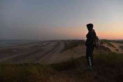 Khaled watches for departures on the dunes of the Slack, in Wimereux, Pas-de-Calais, on September 8, 2021 | Photo : Mehdi Chebil for InfoMigrants