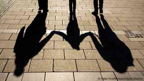 Shadows of two adults and a child | Photo: Peter Kneffel/picture-alliance