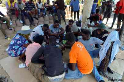 Des migrants partagent un repas dans un parc de Sfax, le 13 juillet 2023. Crédit : Reuters