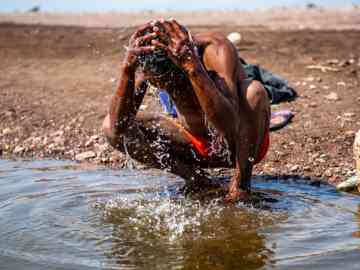 An Ethiopian migrant taking a break and a moment of reprieve to wash his face in Alat Ela, Djibouti | Photo: IOM 2020/Alexander Bee