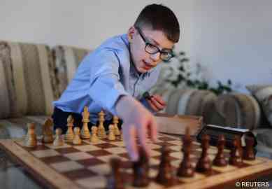 11-year-old chess prodigy Hussain Besou sets up chess pieces at his home in Lippstadt, Germany on April 4, 2023 | Photo: Thilo Schmuelgen/Reuters