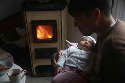 Layana asleep in her father's lap – the family has endured months of feeling isolated and alone in Greece | Photo: Ignacio Pereyra