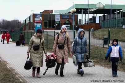 People fleeing from Ukraine walk after crossing the border in Medyka, Poland on March 6, 2022. Thousands of refugees cross the Ukrainian-Polish border after the Russian invasion | Photo:picture alliance/NurPhoto