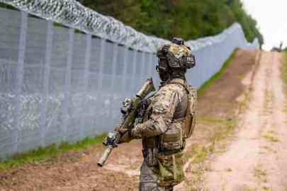 File photo: A member of the State Border Guard (SBG) patrols along the fence at the Latvia/Belarus border near Krivanda, Eastern Latvia on August 8, 2023 | Photo: Gints Ivuskans/AFP