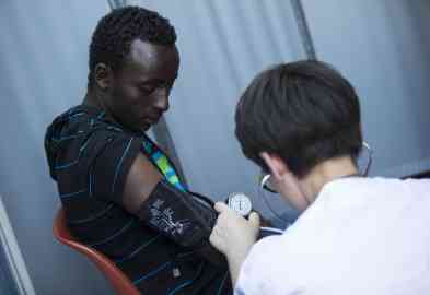 File photo: A healthcare worker measures a migrant's blood pressure | Photo: Massimo Percossi / ANSA