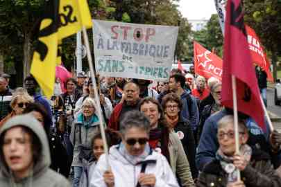 Protesters march with a banner reading 'Stop the creation of undocumented people' in a Paris suburb on May 7, 2025 | Photo: AFP