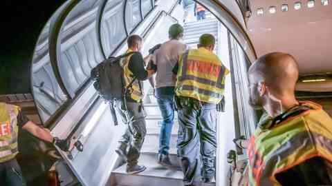 From file: Police officers accompany a deportee into an airplane | Photo: Michael Kappeler/dpa/picture alliance