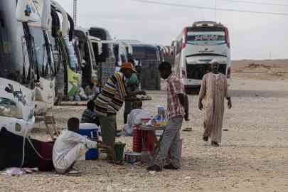 Sudanese drivers wait by their buses upon arrival at the Egyptian village of Wadi Karkar near Aswan on May 14, 2023 after fleeing war-torn Sudan | Photo: Khaled Desouki, AFP 