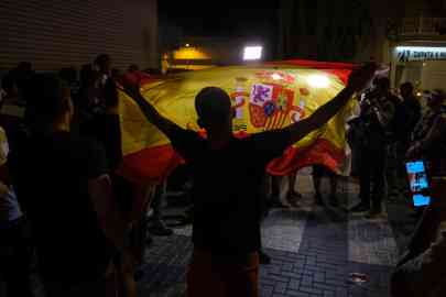 File photo:  A demonstrator raises a Spanish national flag during a protest in the town of Torre Pacheco, Murcia, southeastern Spain | Photo: Pablo Miranzo / EPA