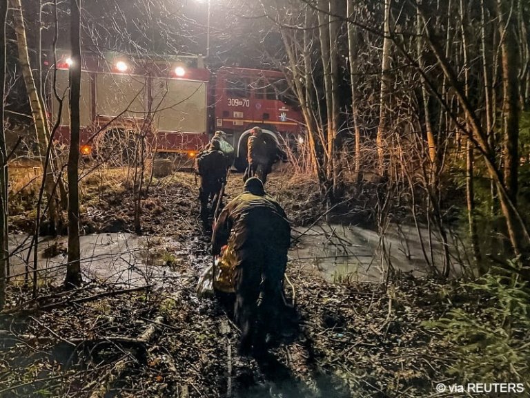 From file: Polish officials transport a migrant towards a fire truck near the Polish-Belarusian border, Poland | Photo: Polish Territorial Defence Forces via REUTERS