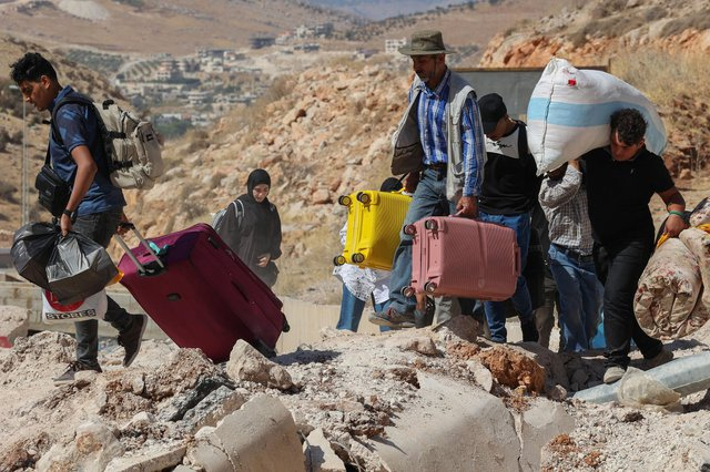 Syrian and Lebanese refugees fleeing Israel's bombardments in the south of Lebanon and the suburbs of Beirut, walk at Massna border crossing, Lebanon, 06 October 2024 | Photo: EPA/JOAO RELVAS