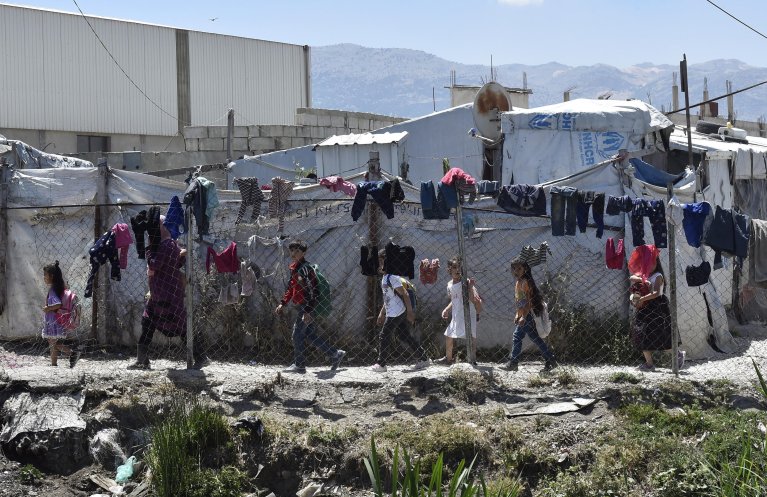 Syrian refugee children walking next to makeshift shelters in a Syrian refugee camp in the Marj area at Bekaa Valley, Lebanon. | PHOTO/ARCHIVE/EPA/WAEL HAMZEH