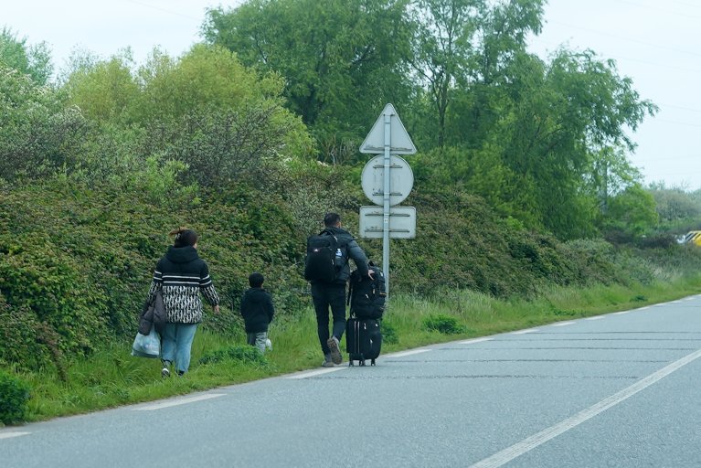 Des exilés marchent le long d'une route, près de Dunkerque, en mai 2024. Image d'illustration. Crédit : InfoMigrants