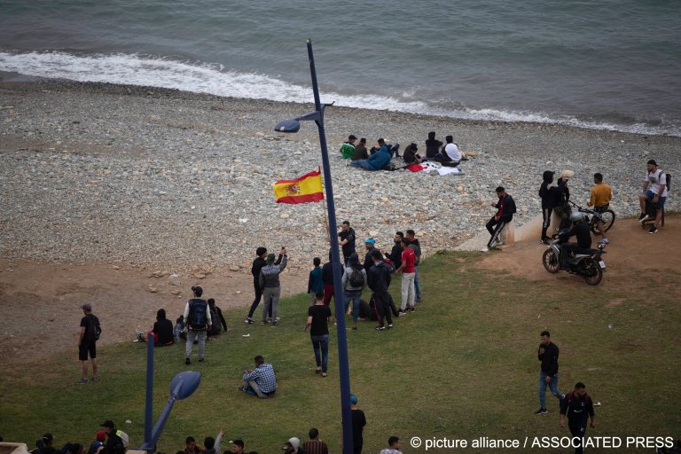 Des jeunes marocains brandissent un drapeau espagnol alors qu'ils tentent de traverser vers l'enclave espagnole de Ceuta, à Fnideq, au Maroc, en mai 2021. Crédit : Picture alliance