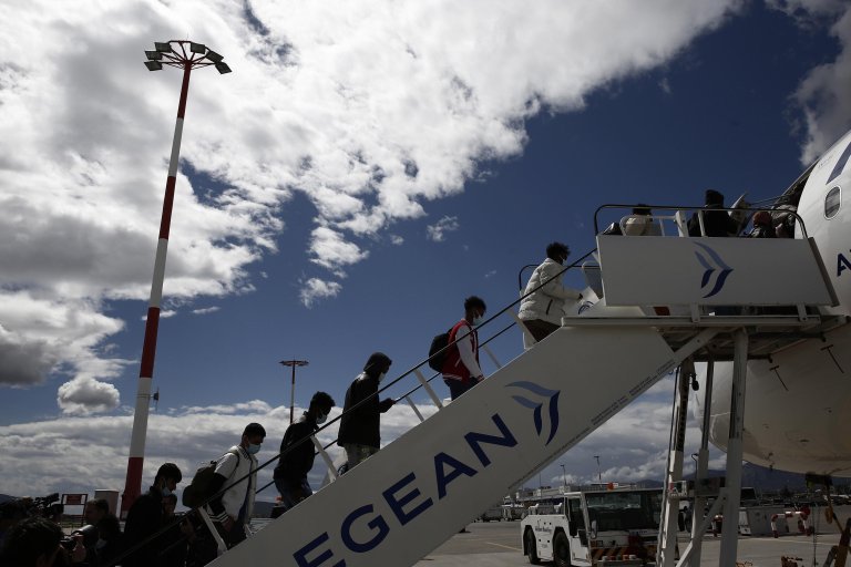A group of unaccompanied minors from Somalia, Gambia and Pakistan board a plane bound for Lisbon, Portugal, at the Athens Eleftherios Venizelos Airport in Spata, near Athens, Greece | Photo: ARCHIVE/EPA/YANNIS KOLESIDIS